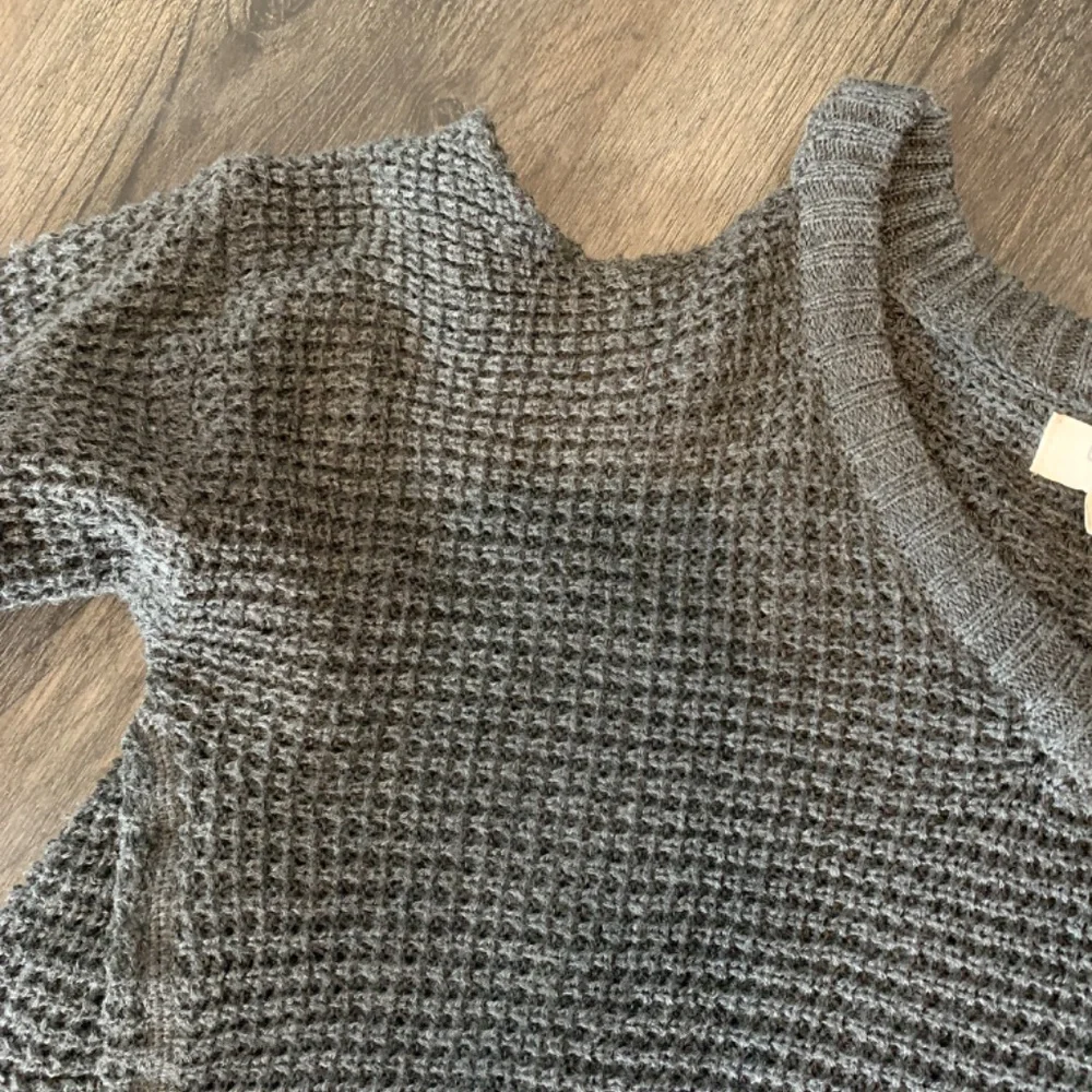 Umgee waffle knit cold‎ shoulder fringed sweater in charcoal.